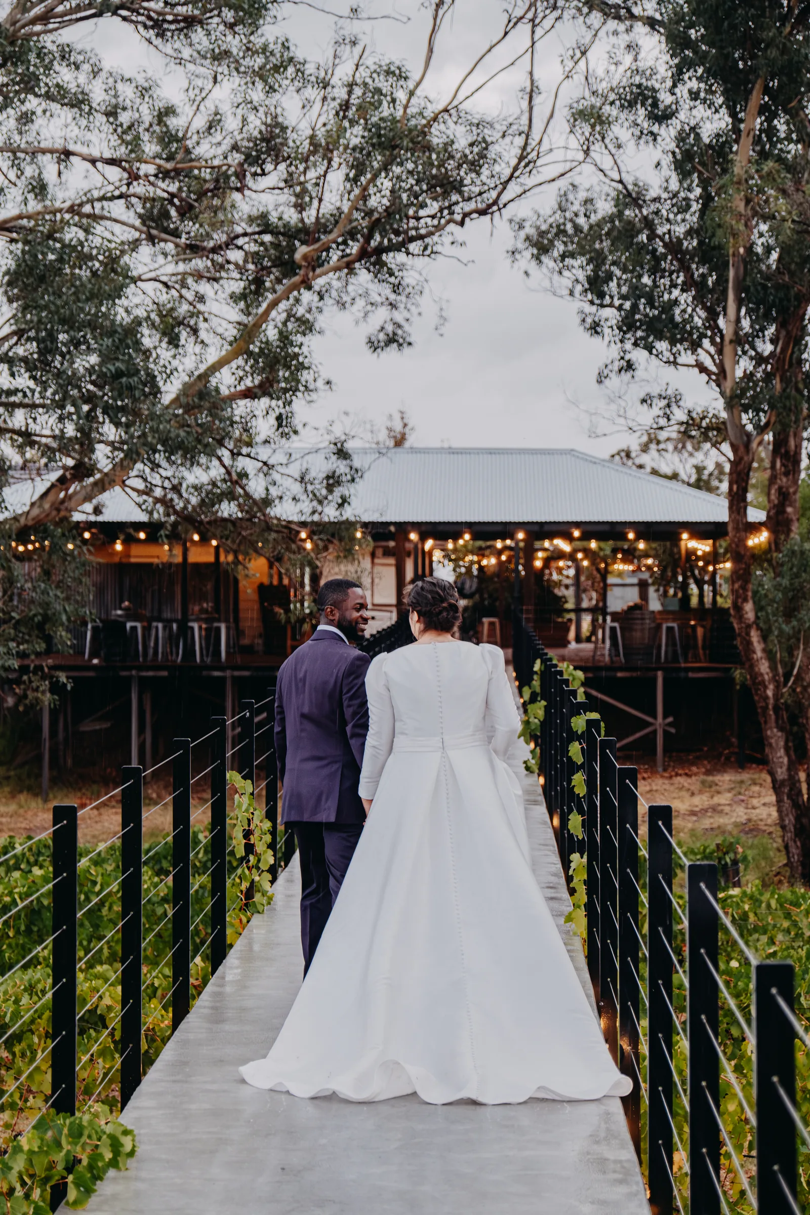 Cassandra and Jonathan walking hand in hand toward a vintage-style horse-drawn coach at Chapel Farm Estate