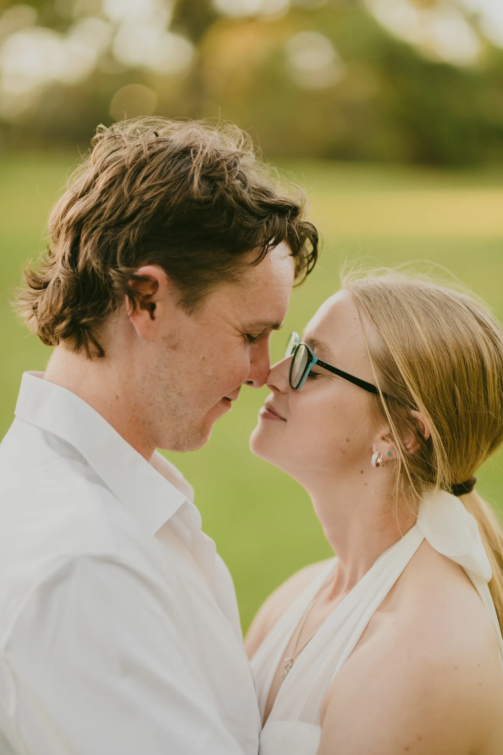 Kayla and Brett with foreheads touching, smiling at Kings Park during golden hour