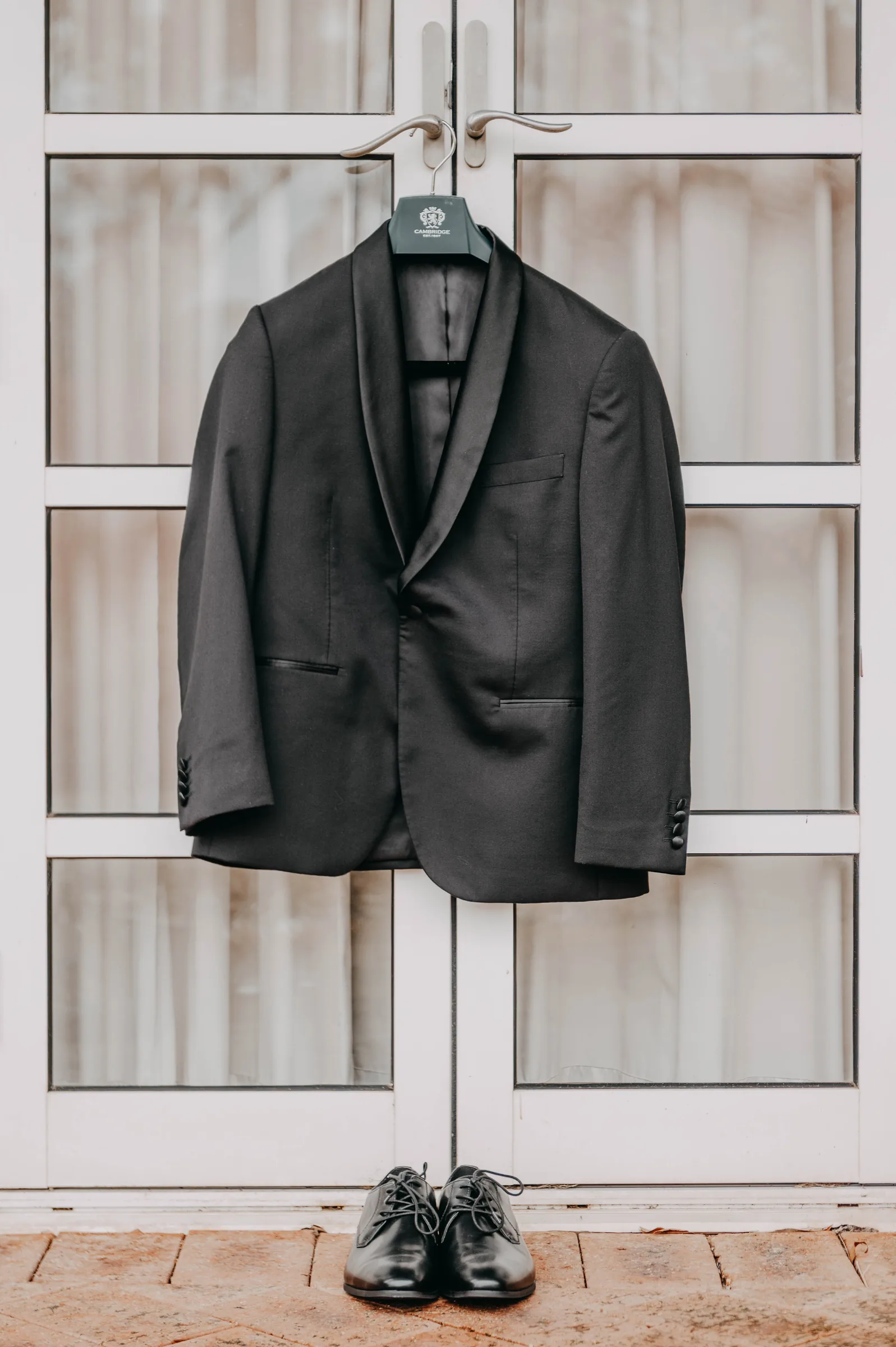 Mitch's suit jacket hanging in the window before his wedding at The Vines Resort