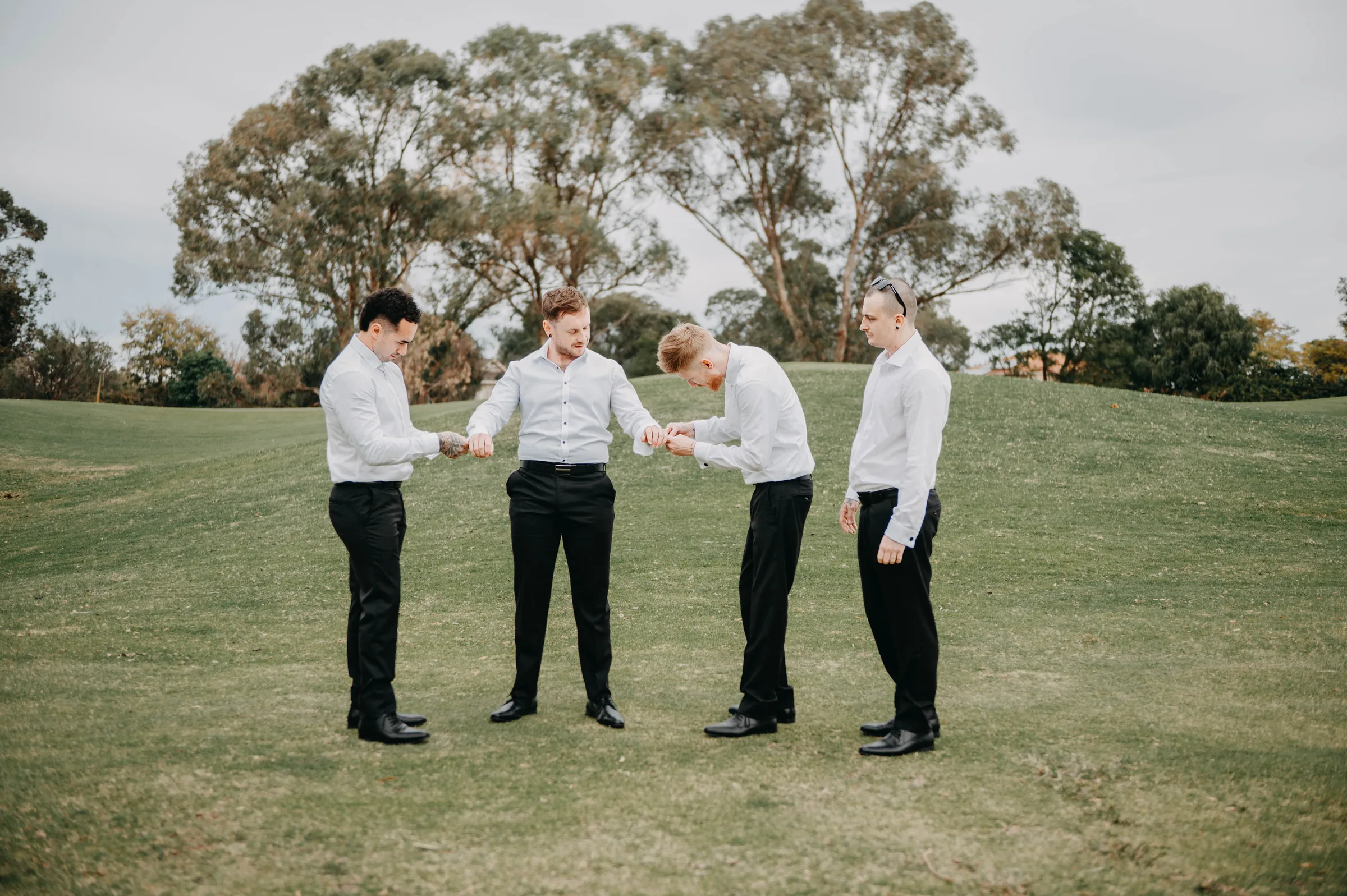 Mitch and his groomsmen standing together on the lawn at The Vines Resort before the ceremony