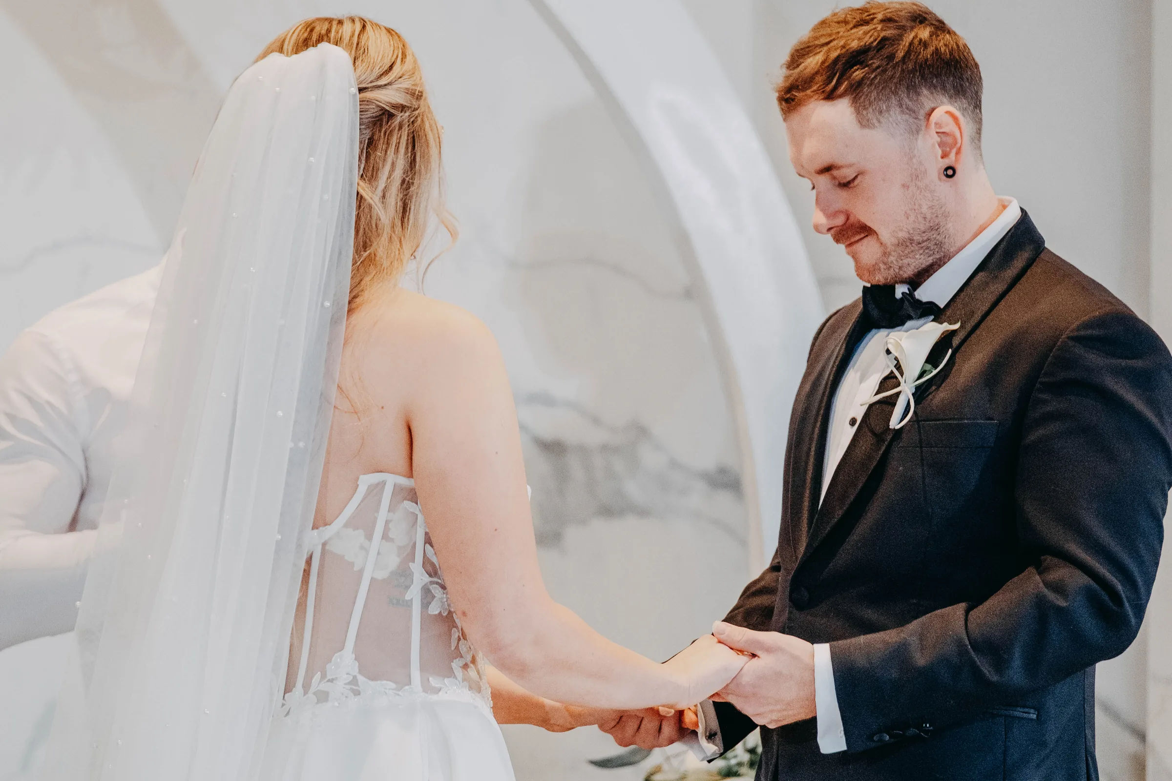 Kirra and Mitch holding hands during their vow exchange at the Garden Pavilion, The Vines Resort