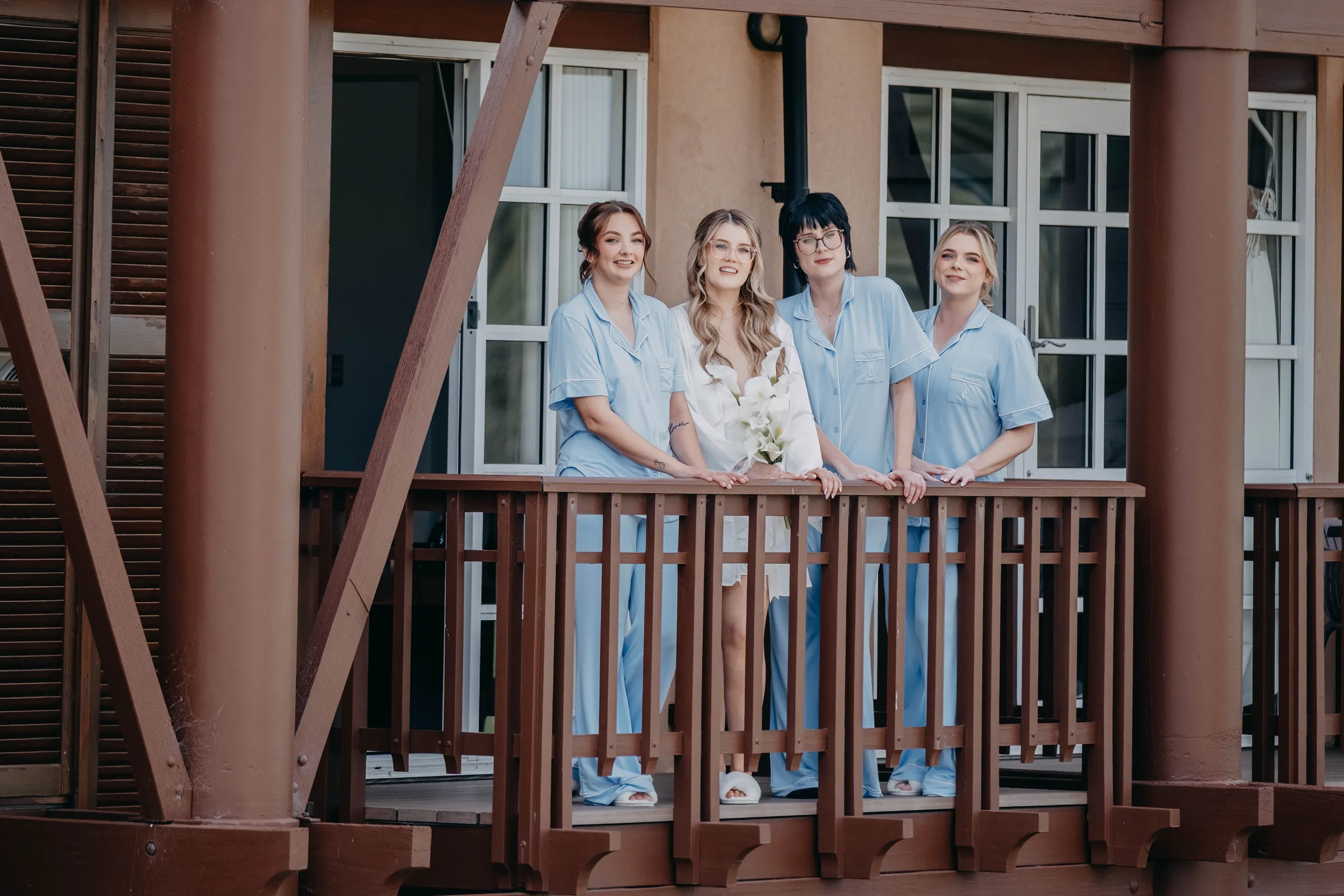 Kirra's bridesmaids standing together on The Vines Resort balcony before the ceremony
