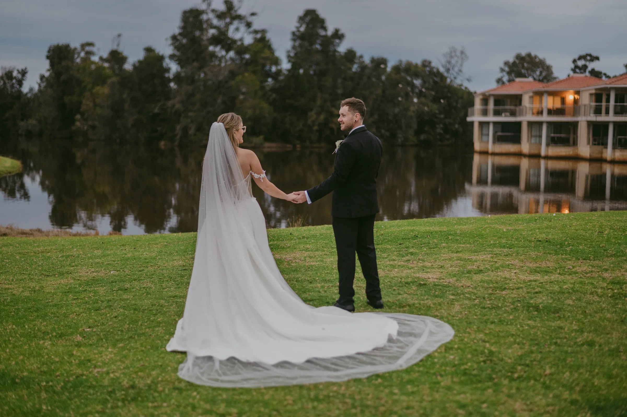 Kirra and Mitch beside The Vines Resort lake as the sky turns to dusk
