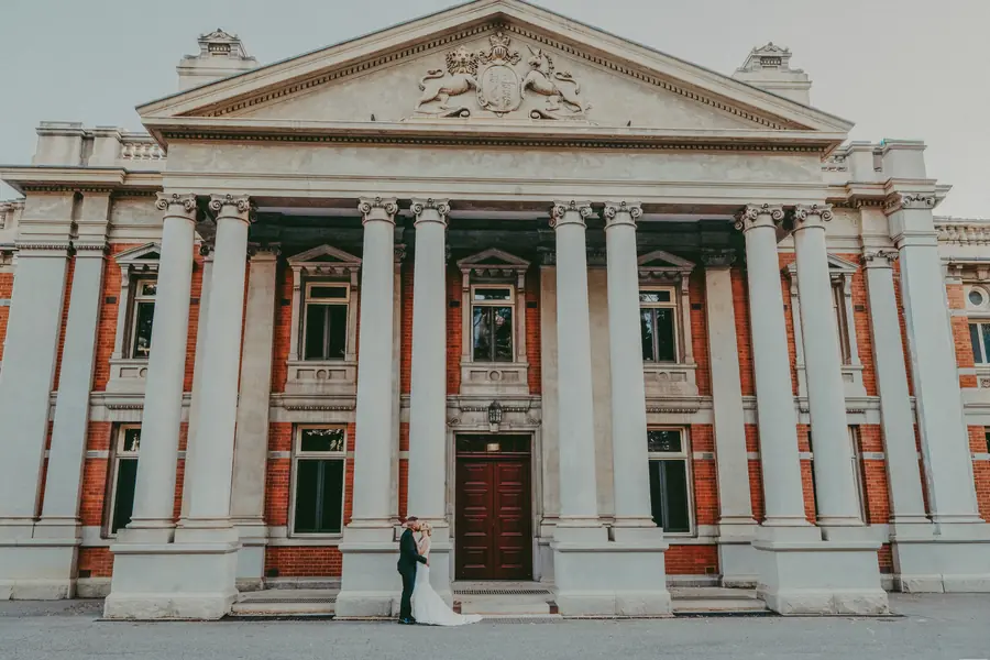 Chantelle and Zach kissing in front of the heritage Supreme Court Gardens building, Perth CBD