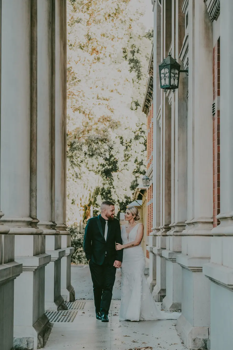 Chantelle and Zach sitting together and kissing on heritage stone steps, Perth CBD wedding