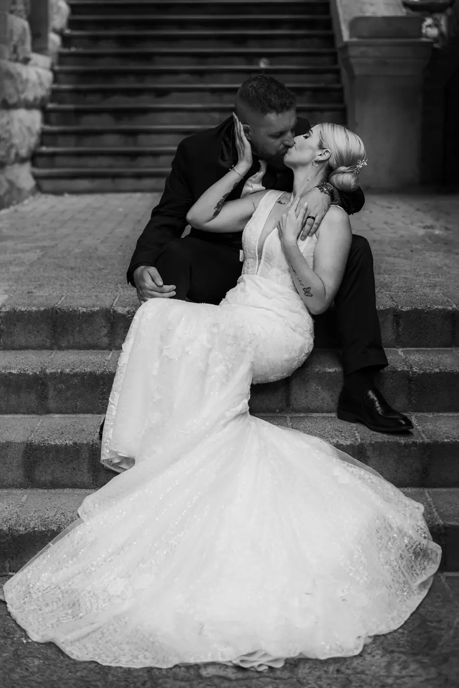 Black and white portrait of newlyweds kissing on heritage stone steps, Perth wedding photography