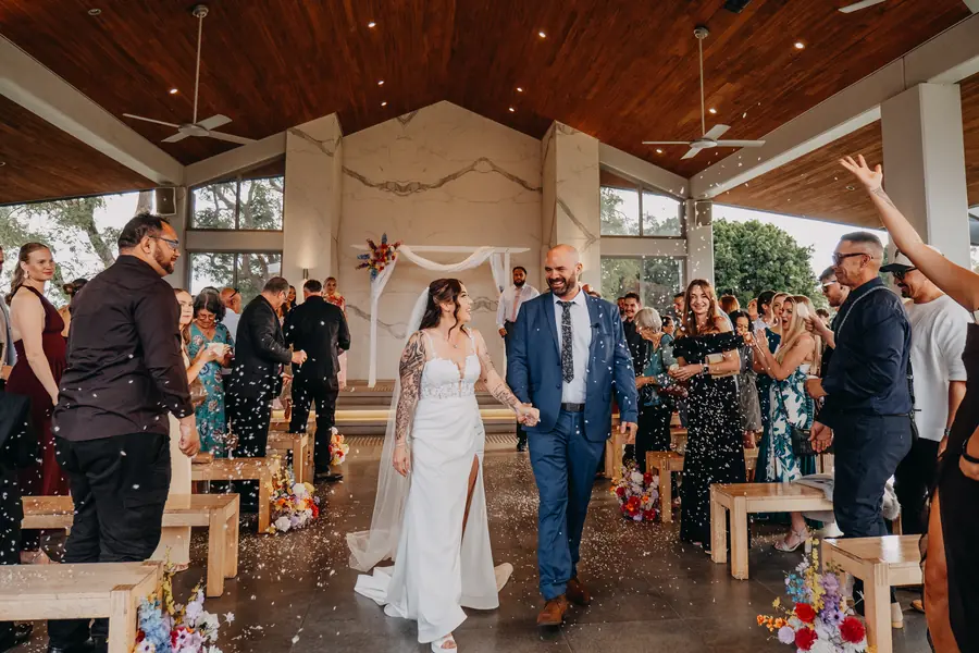 Guests cheering as Kerry and Richard walk back down the aisle at their ceremony