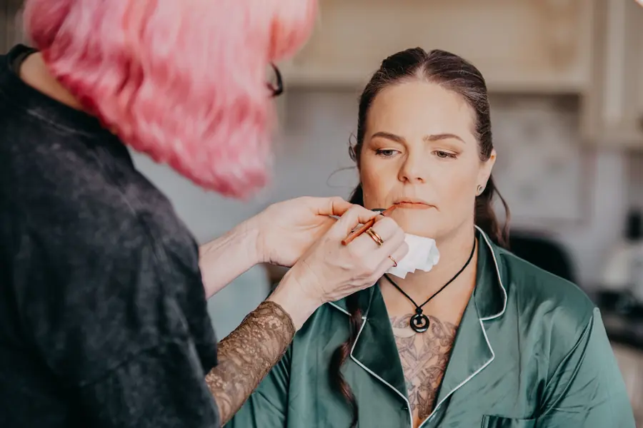 Makeup artist applying Liv's bridal makeup on the morning of her Dalmore Farm wedding