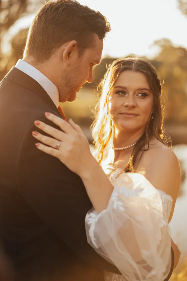 Bride and groom foreheads together, golden hour light catching the bride's face