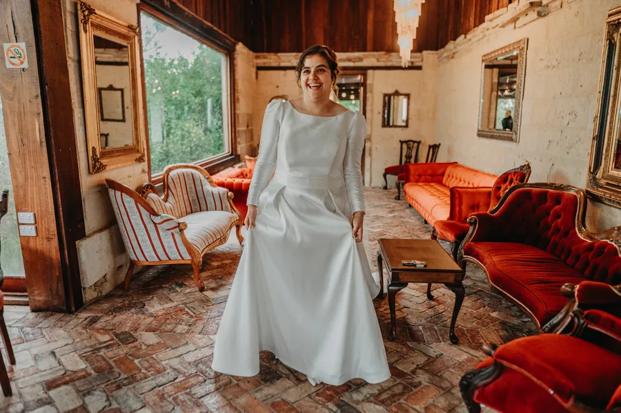 Cassandra alone in the red-leather-chair room at Chapel Farm Estate before the ceremony