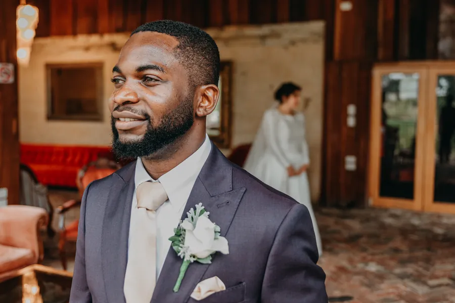 Jonathan smiling warmly at Cassandra in the rustic red-leather-chair room at Chapel Farm Estate