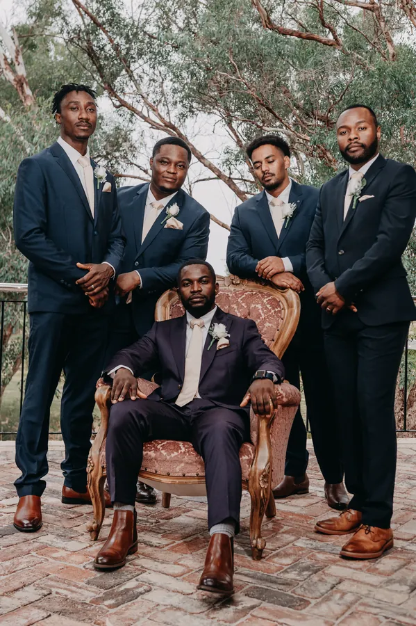 Jonathan and his groomsmen posing in the red-leather-chair room at Chapel Farm Estate