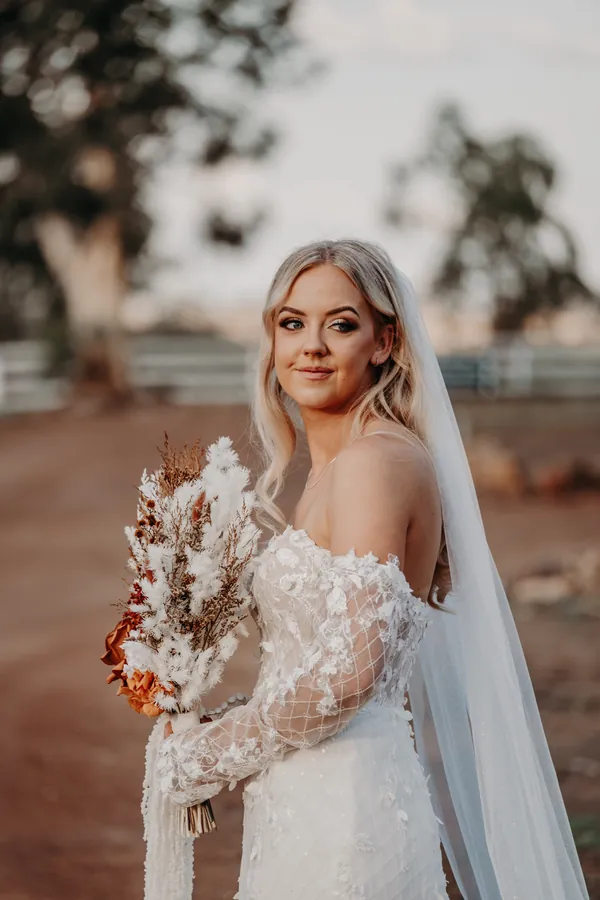 Grace holding her dried floral bouquet in soft afternoon light at Buckland Estate