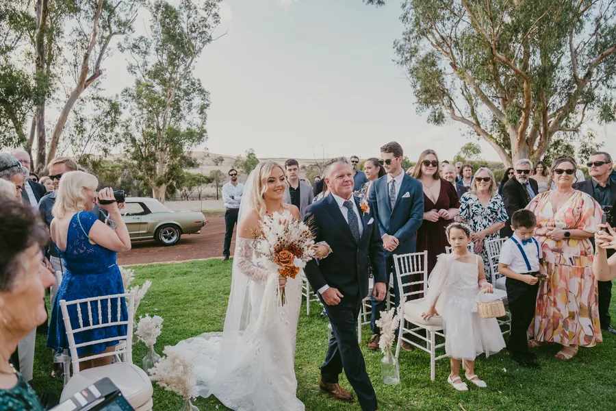 Grace walking down the aisle toward Lachie at their Buckland Estate ceremony