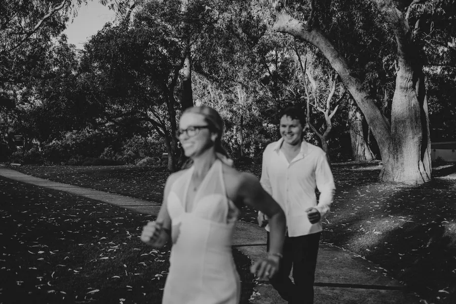 Black and white photo of Kayla and Brett walking and laughing together on a Kings Park pathway