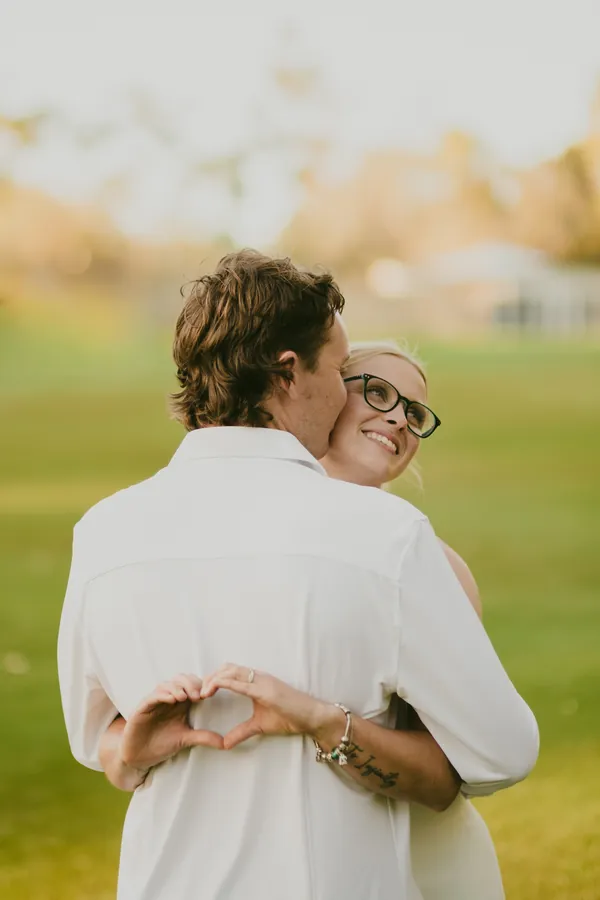 Kayla and Brett embracing in an open field at Kings Park during their pre-wedding session