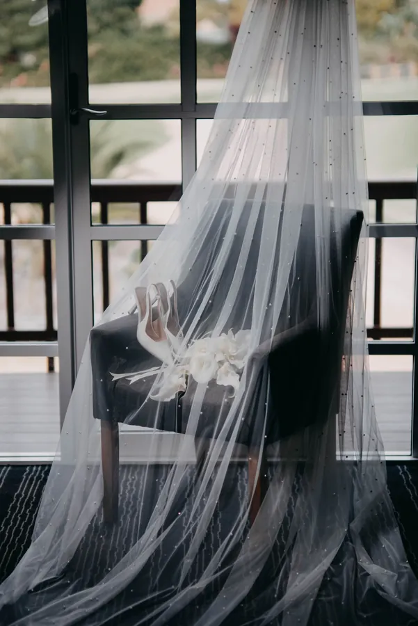 Detail of Kirra's wedding veil and floral trim hanging in the window at The Vines Resort