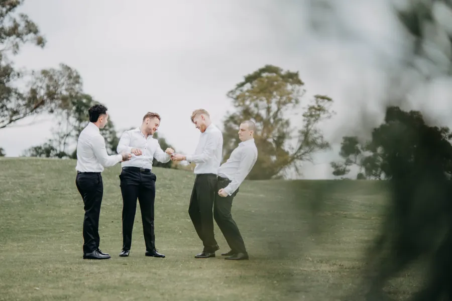 Mitch and his groomsmen laughing together on the open fairway at The Vines Resort