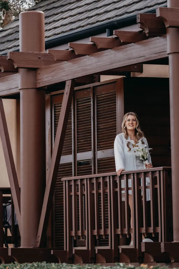 Bridesmaid standing on the balcony at The Vines Resort before Kirra and Mitch's wedding